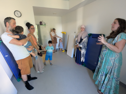 Parents enfants écoutent les explications sur le service petite enfance par la Directrice