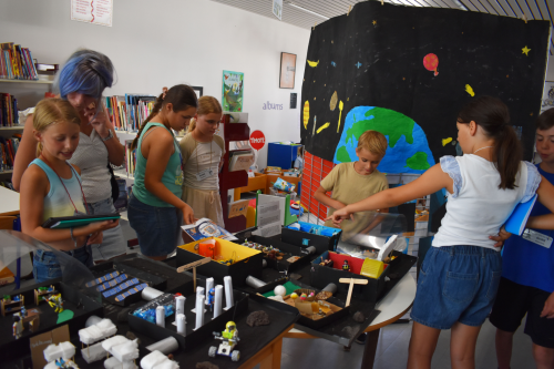les enfants présentent aux parents l'exposition mon école sur la lune